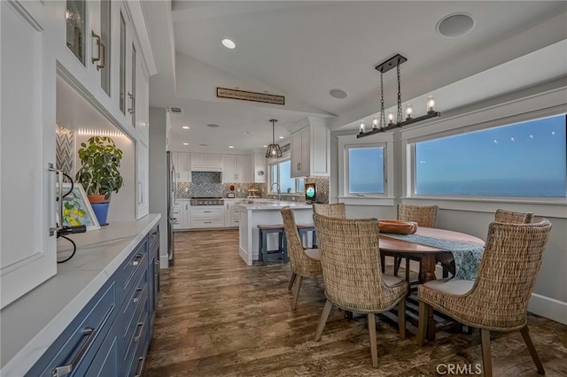 dining space featuring recessed lighting, vaulted ceiling, and dark wood finished floors