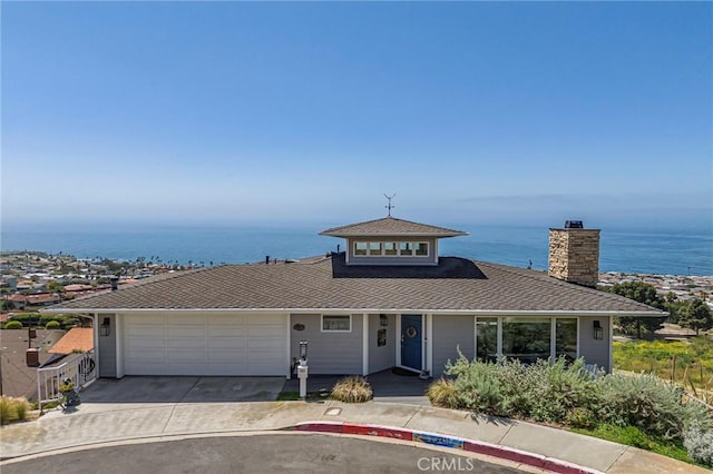 view of front facade with a garage and a water view