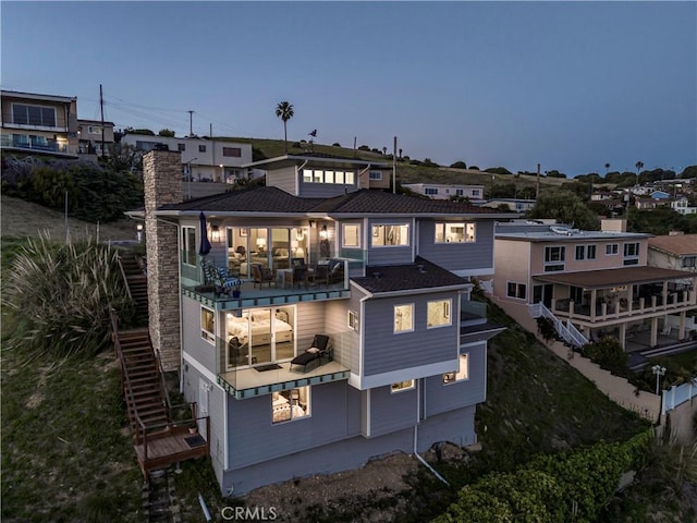 back house at dusk with a balcony