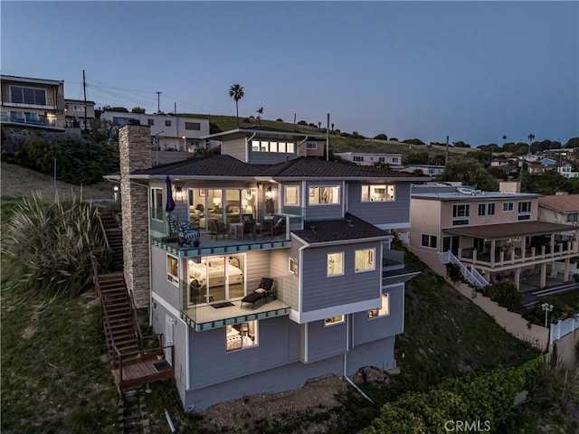 back of property featuring stairway and a balcony