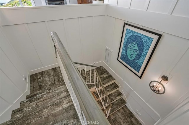staircase featuring visible vents and a decorative wall