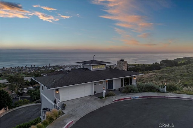 view of front of house featuring a garage and a water view