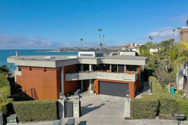 view of front of property with a garage and a water view