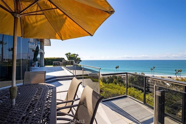 balcony with a water view and a beach view