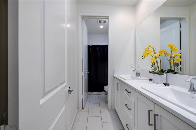 bathroom with vanity, toilet, and tile patterned flooring