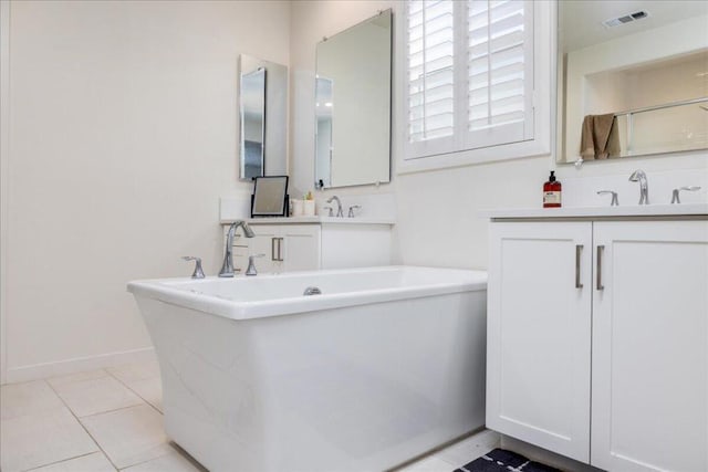 bathroom with tile patterned floors, a bath, and vanity