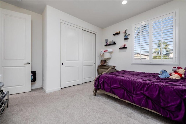 bedroom featuring light colored carpet and a closet