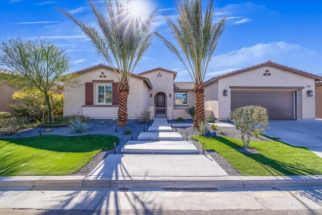 mediterranean / spanish-style house featuring a garage and a front lawn