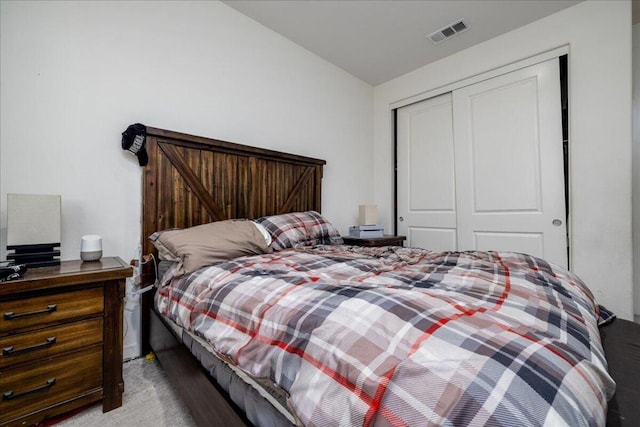 carpeted bedroom with a closet and lofted ceiling