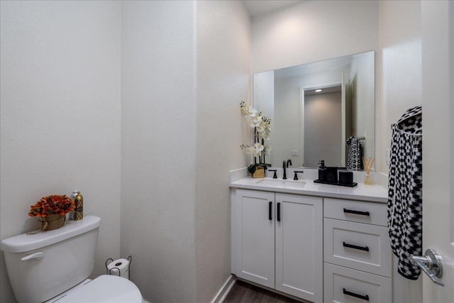 bathroom featuring hardwood / wood-style flooring, toilet, and vanity