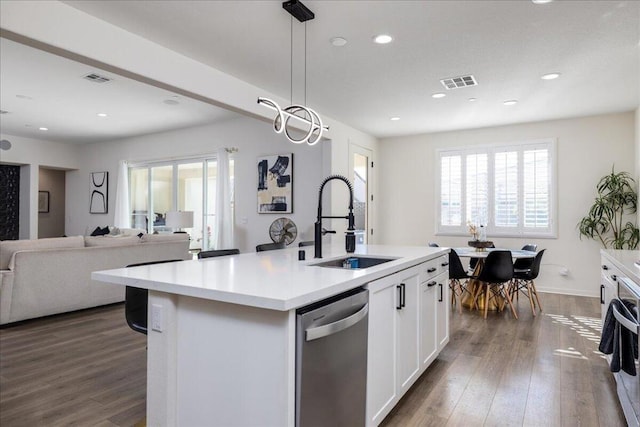 kitchen featuring white cabinetry, stainless steel dishwasher, sink, a center island with sink, and dark hardwood / wood-style floors