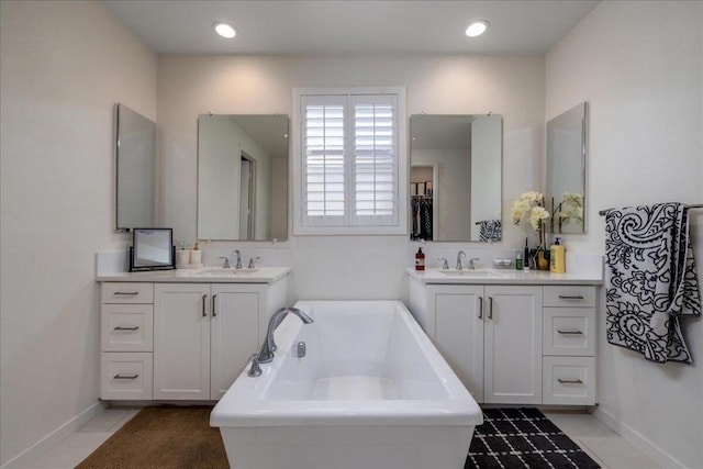 bathroom with a bath, tile patterned flooring, and vanity