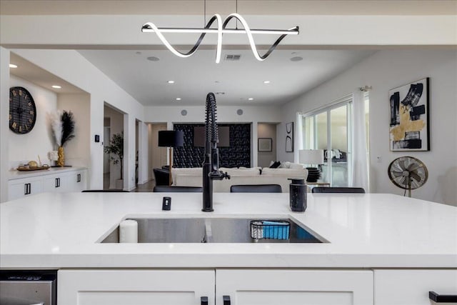 kitchen featuring stainless steel dishwasher, sink, and white cabinets