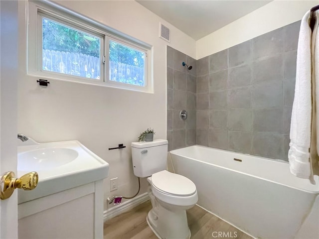 full bathroom featuring hardwood / wood-style flooring, toilet, vanity, and tiled shower / bath combo