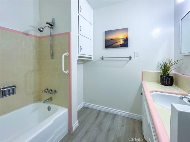 bathroom with vanity, hardwood / wood-style flooring, and tiled shower / bath combo