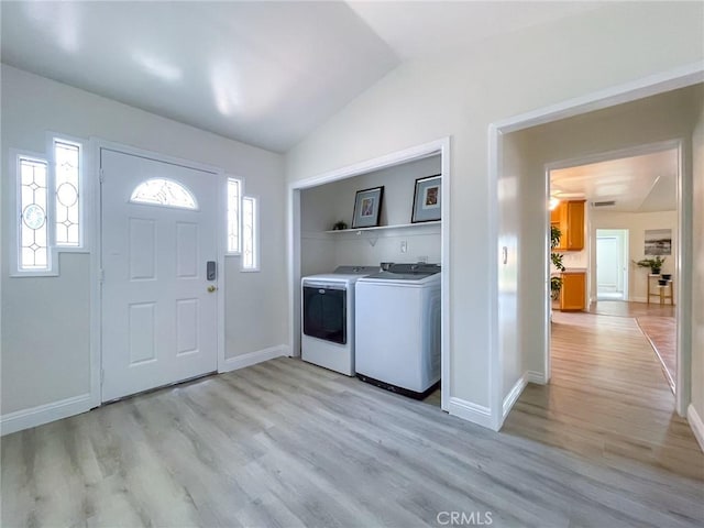 clothes washing area featuring washing machine and dryer and light hardwood / wood-style flooring