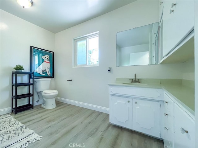 bathroom with wood-type flooring, toilet, and vanity