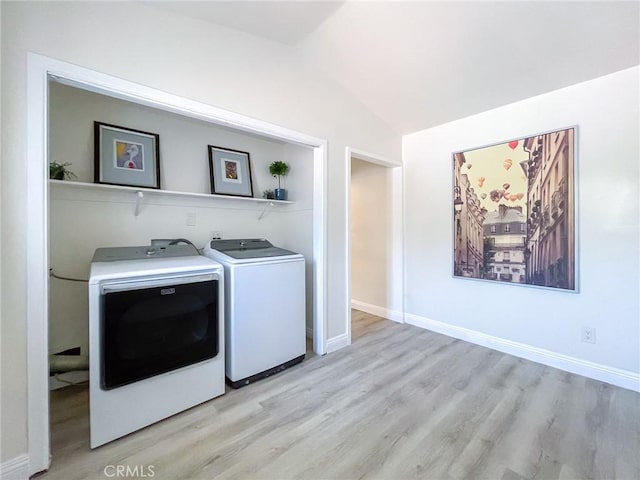 laundry area featuring washer and dryer and light hardwood / wood-style floors