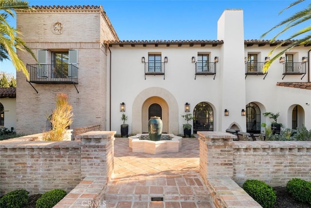 view of front of house with a balcony and a patio area