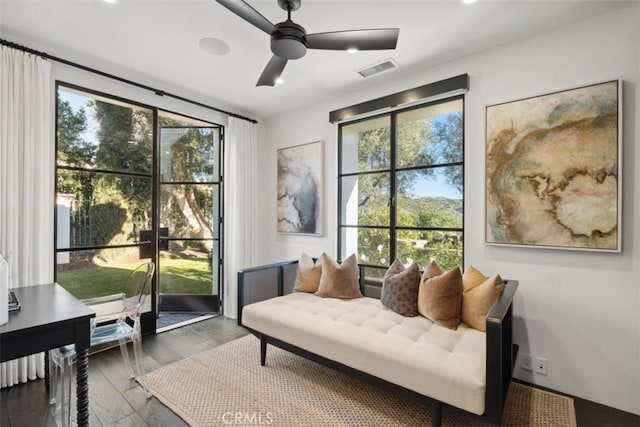 living area with dark wood-type flooring and ceiling fan