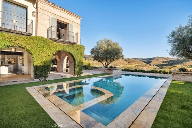 view of swimming pool featuring an in ground hot tub, a mountain view, a yard, and a patio