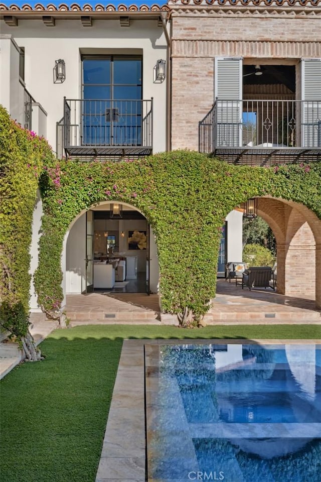 back of house with a balcony and a patio