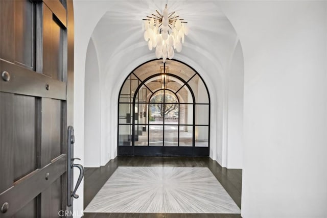 foyer featuring lofted ceiling and a chandelier