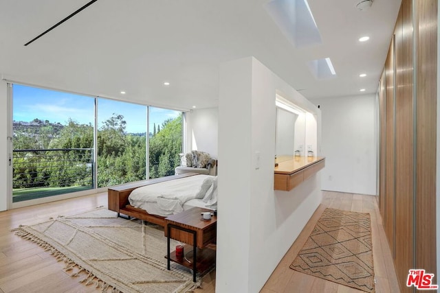 bedroom featuring light hardwood / wood-style flooring and expansive windows