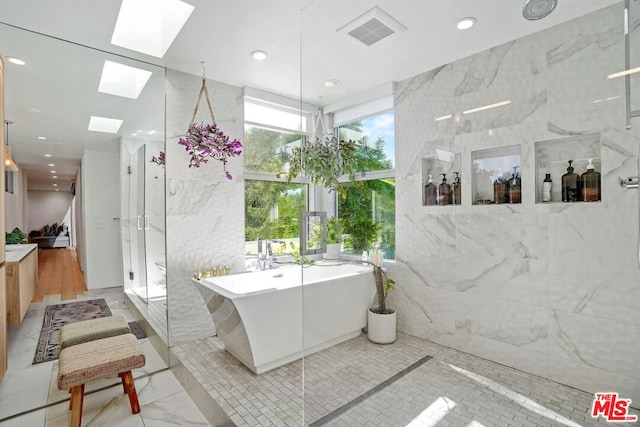 bathroom with tile walls, a skylight, and shower with separate bathtub