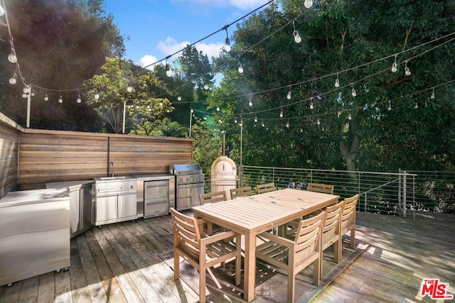 wooden deck with sink, an outdoor kitchen, and grilling area