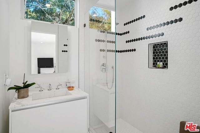 bathroom with vanity and a tile shower