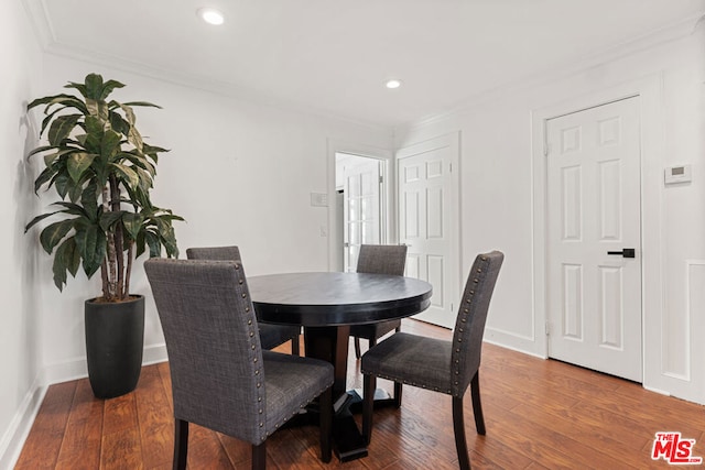 dining space with crown molding and dark hardwood / wood-style floors