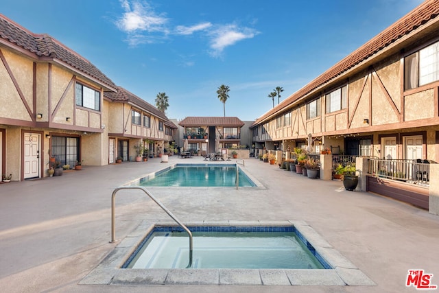 view of swimming pool featuring a patio area and a hot tub