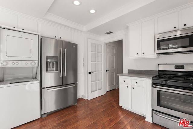 kitchen with white cabinets, stainless steel appliances, dark hardwood / wood-style flooring, and stacked washer and dryer