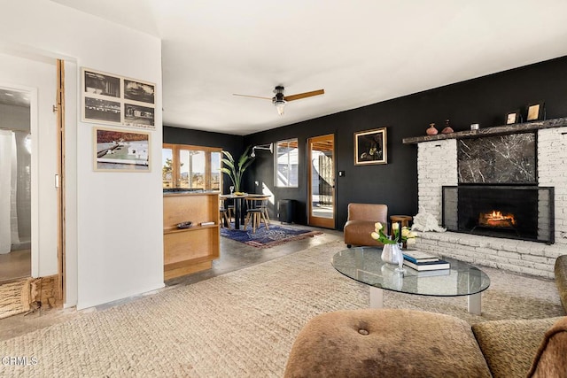 living room with ceiling fan, concrete flooring, and a fireplace