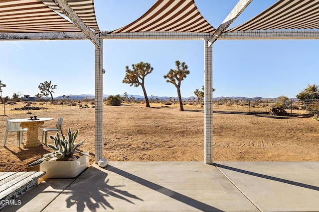 view of yard with fence, a rural view, a pergola, and a patio area