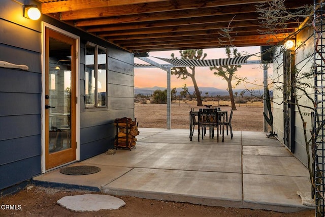 patio terrace at dusk featuring a pergola