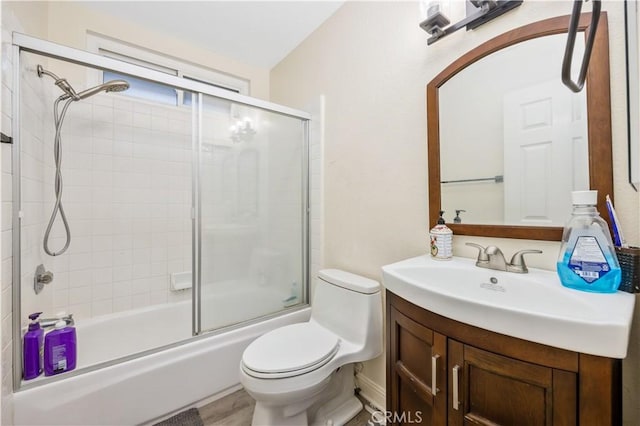 full bathroom with vanity, toilet, and combined bath / shower with glass door