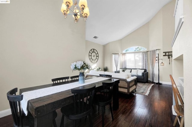 dining space with high vaulted ceiling, dark wood-type flooring, and a chandelier