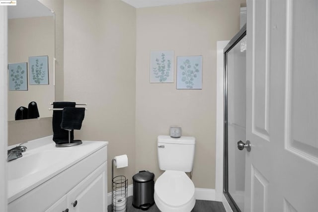 bathroom featuring vanity, toilet, and walk in shower