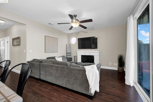 living room with plenty of natural light, dark hardwood / wood-style flooring, and a brick fireplace