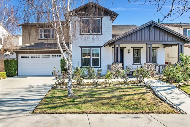 view of front of home featuring a garage, a front lawn, and covered porch