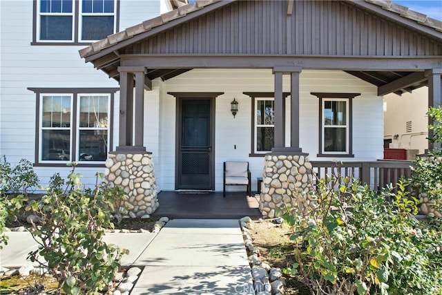 view of exterior entry featuring covered porch