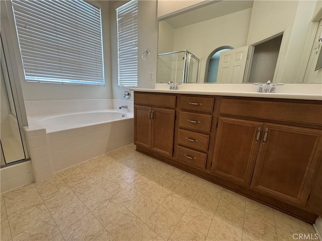 bathroom with vanity, a healthy amount of sunlight, and separate shower and tub