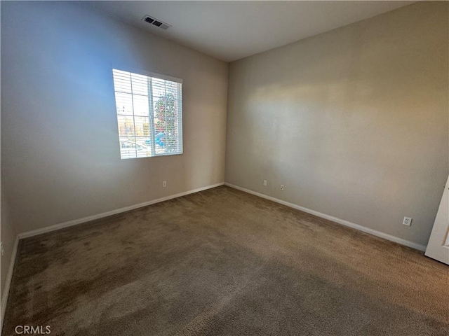 unfurnished room featuring dark carpet