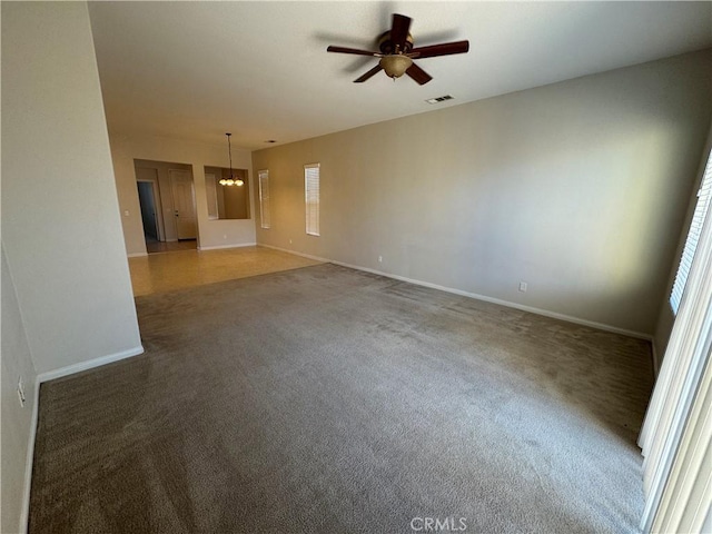 spare room featuring ceiling fan and dark carpet