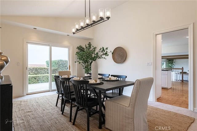 dining room with light parquet floors and vaulted ceiling