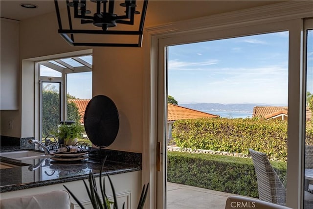 doorway to outside with a water view and sink