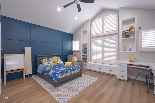 bedroom with ceiling fan, lofted ceiling, built in desk, and light hardwood / wood-style floors