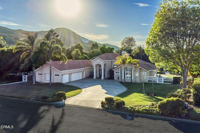 view of front of house featuring a mountain view, a garage, and a front lawn